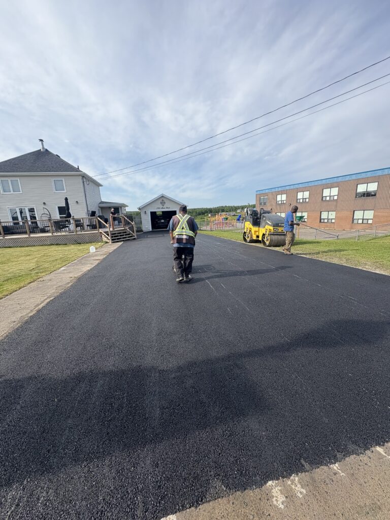“Freshly paved residential driveway asphalt repair in Halifax by 99 Contractors Ltd. using roller compactor equipment"