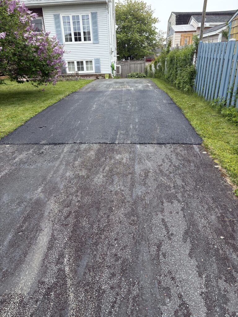 “Freshly paved residential driveway asphalt repair in Halifax by 99 Contractors Ltd. using roller compactor equipment”